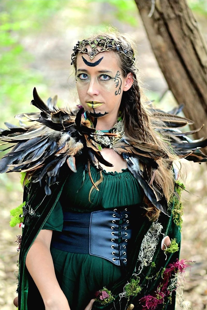 Woman in a feathered cloak and circlet, painted like a raven queen